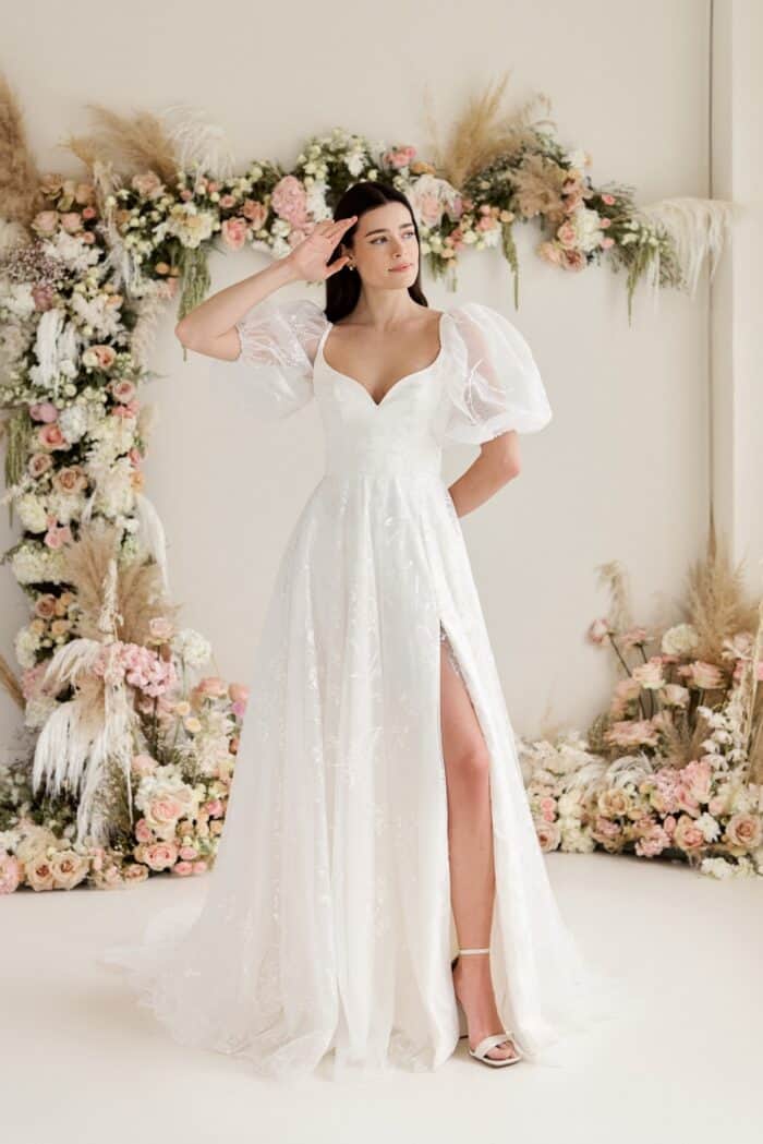 Model in a puffed sleeve minimalist wedding dress with sweeheart neckline and puffed sleeves