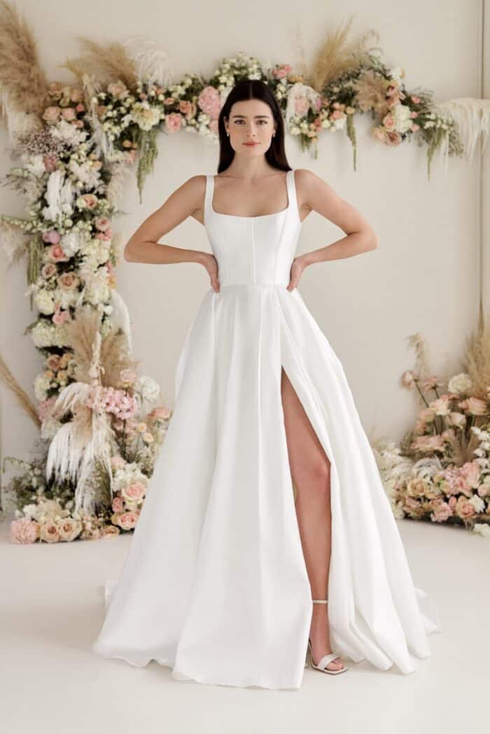 model wearing a wedding dress witha full skirt, square neckline and boning in the bodice